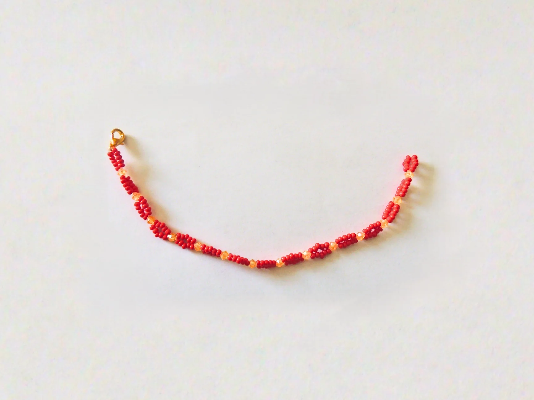 Bracelet Perline — bracelet tissé main en perles rouges et orange, vue rapprochée