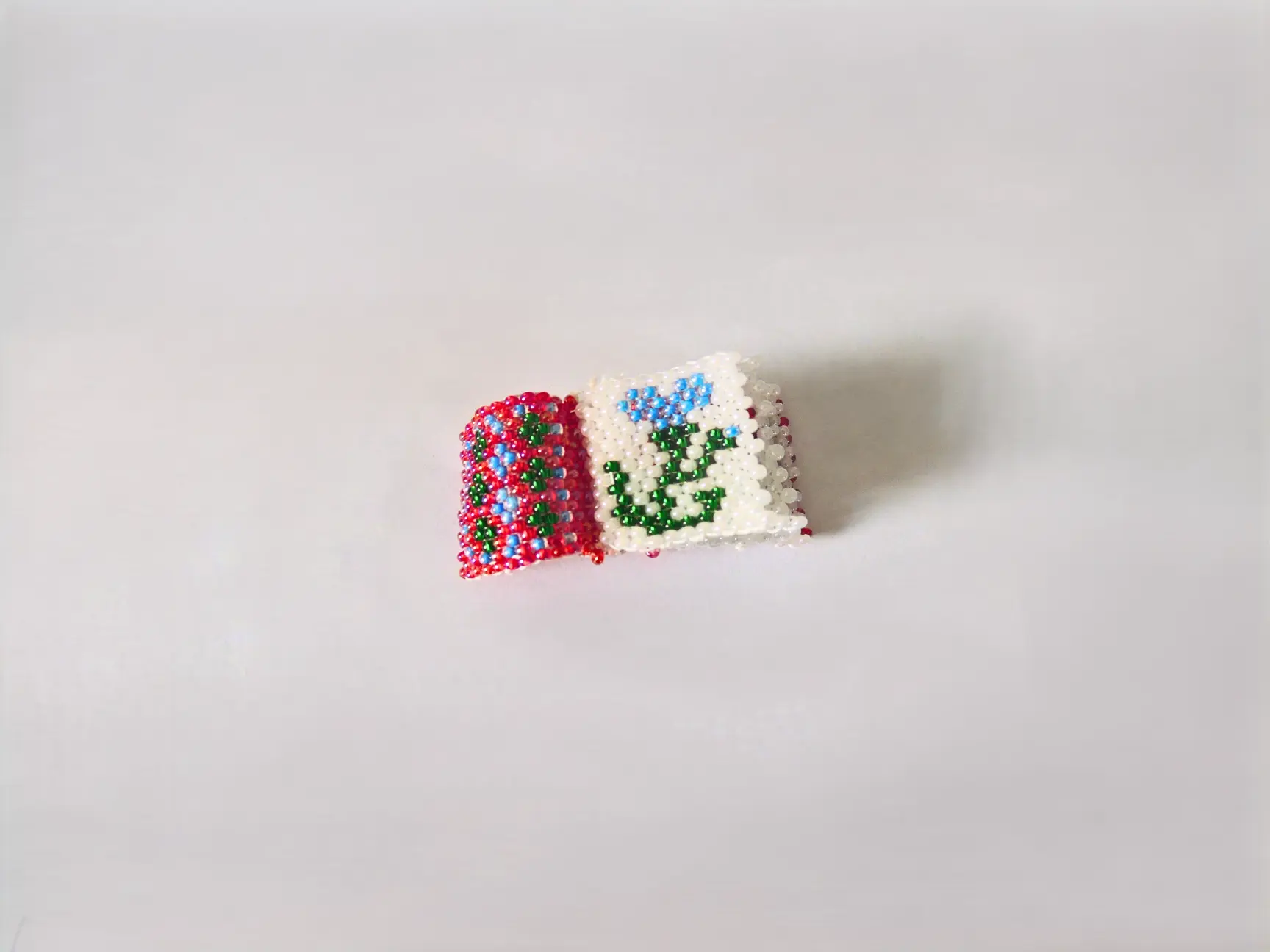 Mini-livret en perles tissé à la main avec motifs floraux.