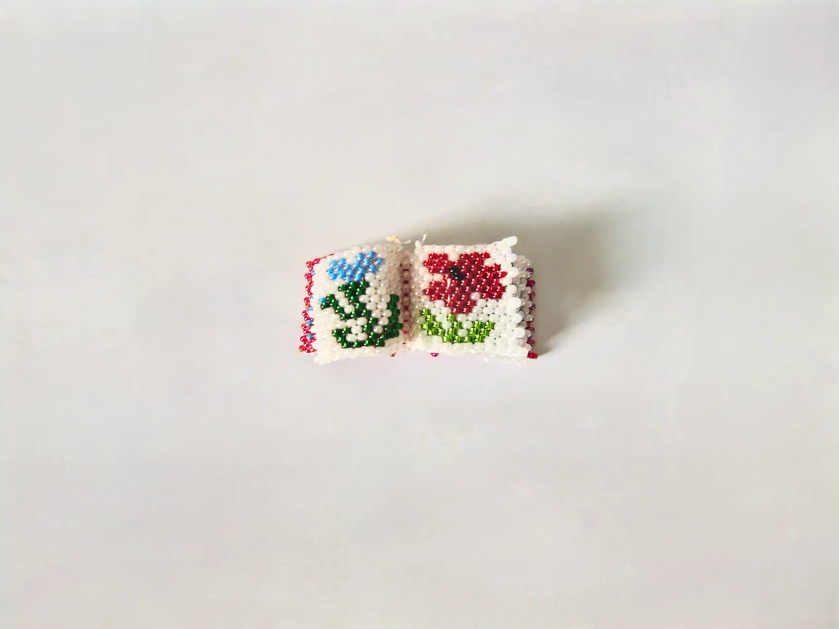 Mini-livret en perles tissé à la main avec motifs floraux.