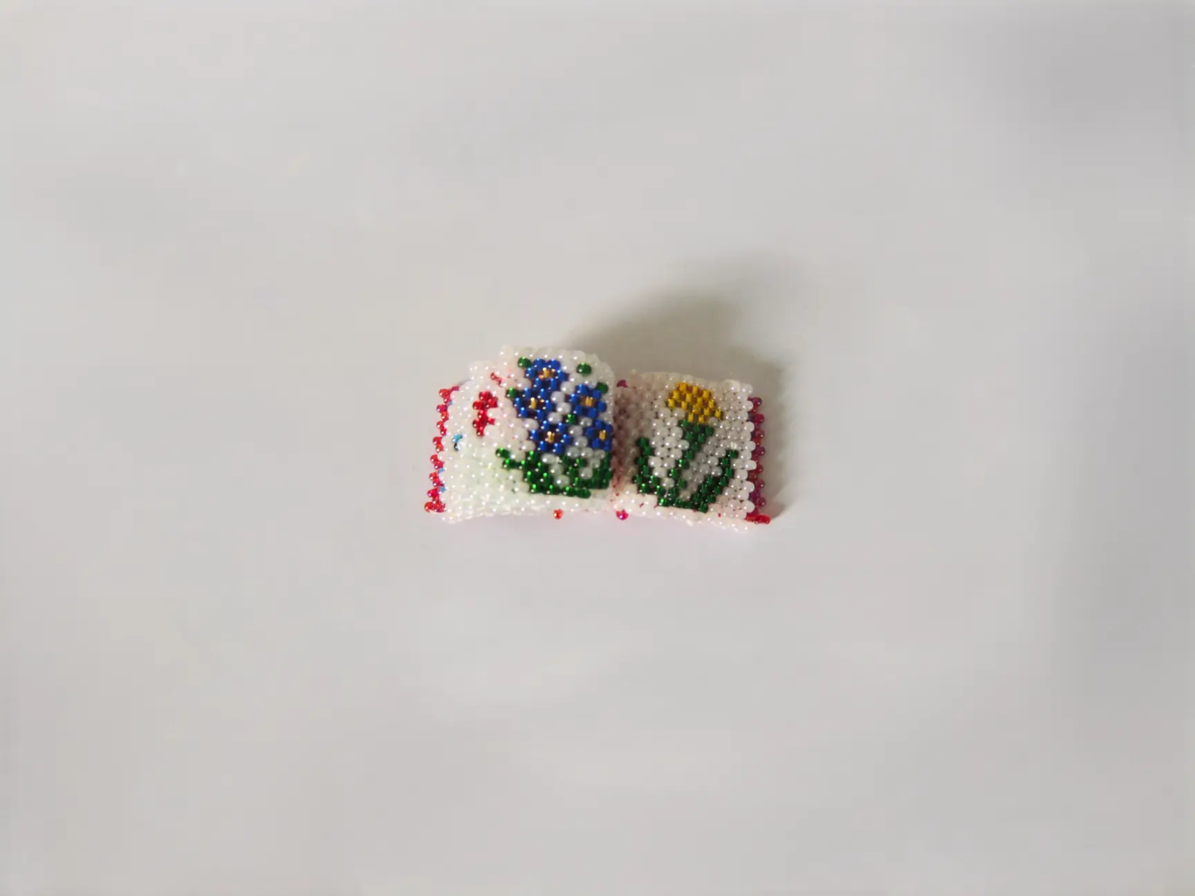 Mini-livret en perles tissé à la main avec motifs floraux.